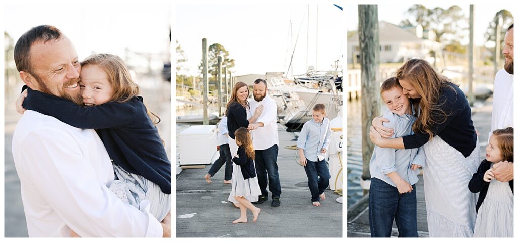 Mom and dad snuggling while kids run around them on dock in one of the best summer portrait locations in virginia beach virginia